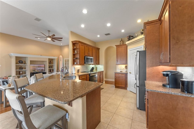 kitchen featuring appliances with stainless steel finishes, sink, a breakfast bar area, ceiling fan, and kitchen peninsula
