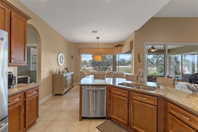 kitchen featuring light tile patterned flooring, sink, hanging light fixtures, stainless steel dishwasher, and light stone countertops
