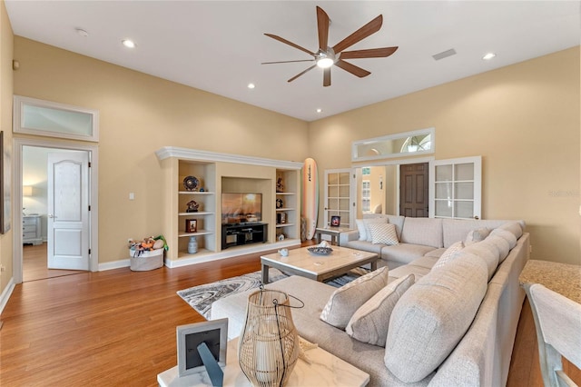 living room featuring ceiling fan and light hardwood / wood-style floors