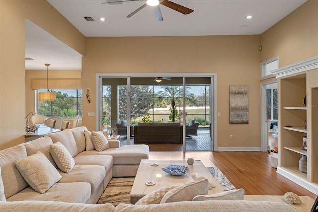 living room featuring light hardwood / wood-style flooring and ceiling fan
