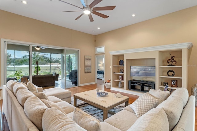 living room with light hardwood / wood-style flooring, built in features, and ceiling fan