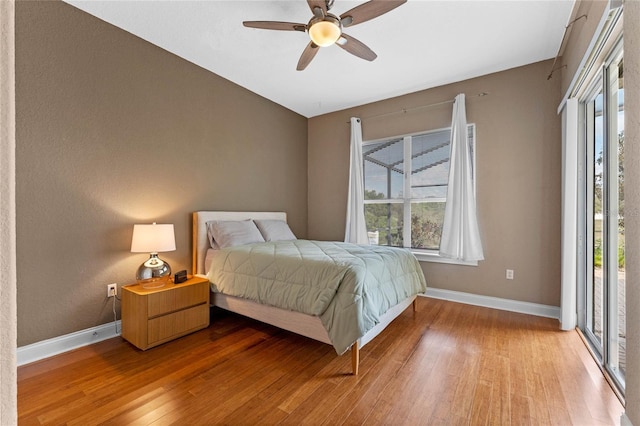 bedroom with hardwood / wood-style flooring, access to exterior, and ceiling fan