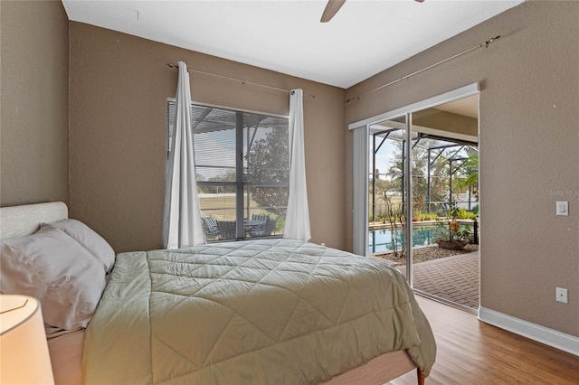 bedroom with hardwood / wood-style floors, access to exterior, and ceiling fan