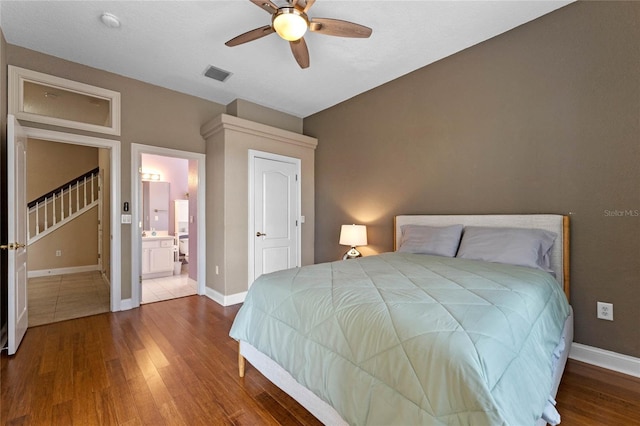 bedroom featuring hardwood / wood-style flooring, ceiling fan, and ensuite bath