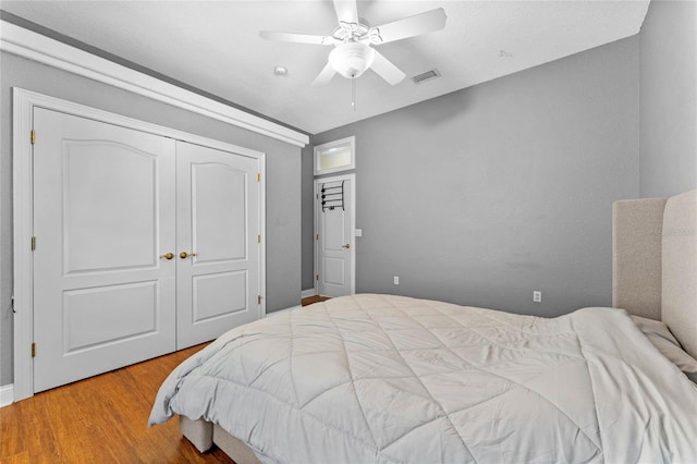 bedroom with wood-type flooring, ceiling fan, and a closet