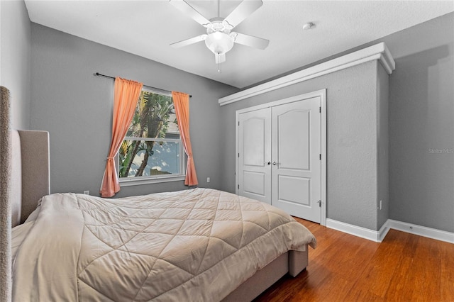 bedroom featuring hardwood / wood-style flooring, ceiling fan, and a closet