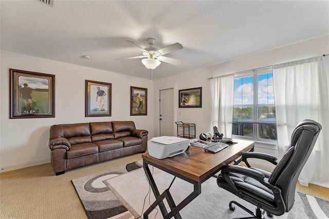 carpeted office space with ceiling fan and a textured ceiling