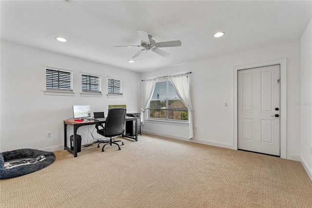 carpeted home office featuring ceiling fan