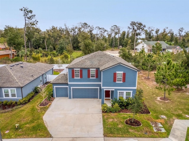 view of property with a garage and a front lawn