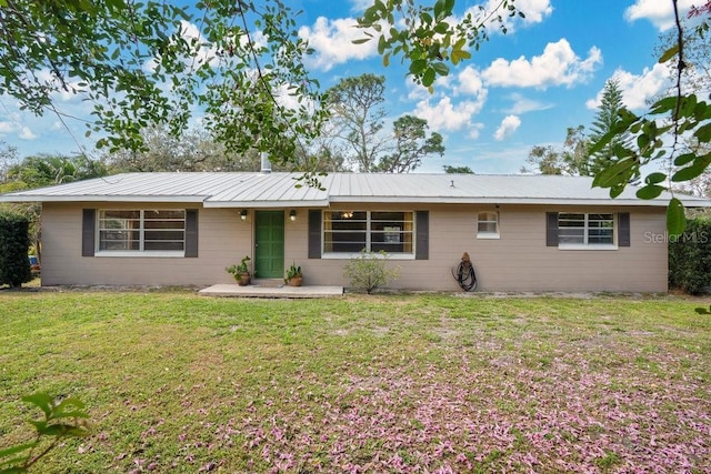 single story home featuring metal roof and a front yard