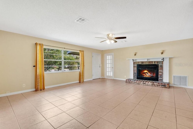 unfurnished living room with visible vents, ceiling fan, light tile patterned flooring, and a brick fireplace