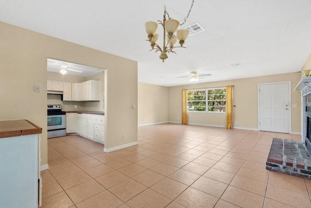 unfurnished living room with ceiling fan with notable chandelier, light tile patterned floors, baseboards, and visible vents