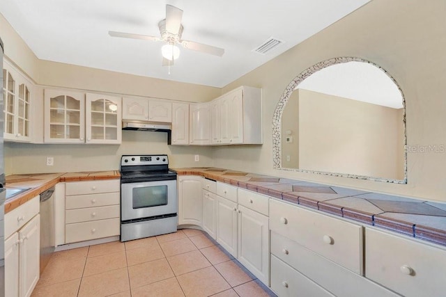 kitchen featuring glass insert cabinets, a ceiling fan, visible vents, appliances with stainless steel finishes, and under cabinet range hood