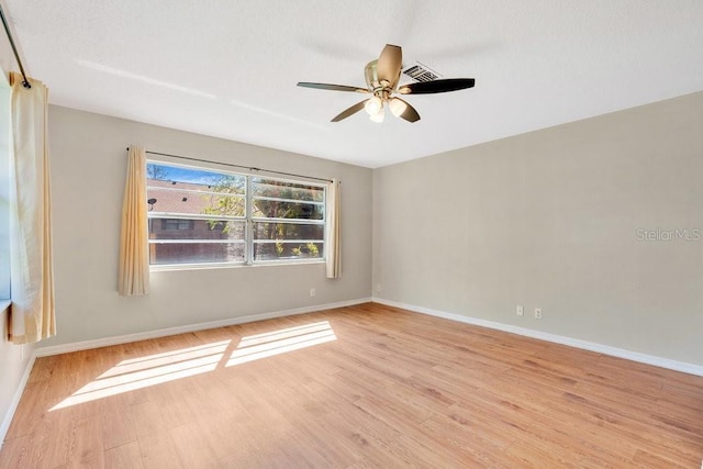 empty room with light wood-type flooring, baseboards, and a ceiling fan