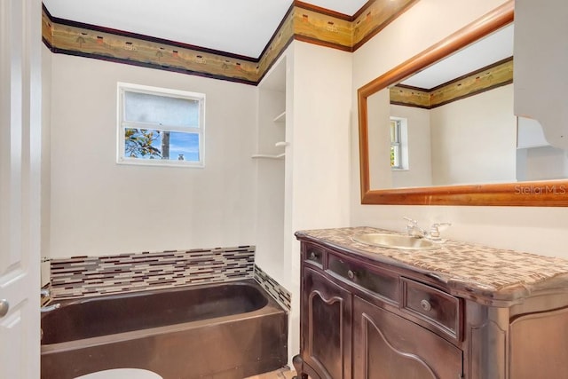 bathroom featuring vanity, crown molding, and a washtub
