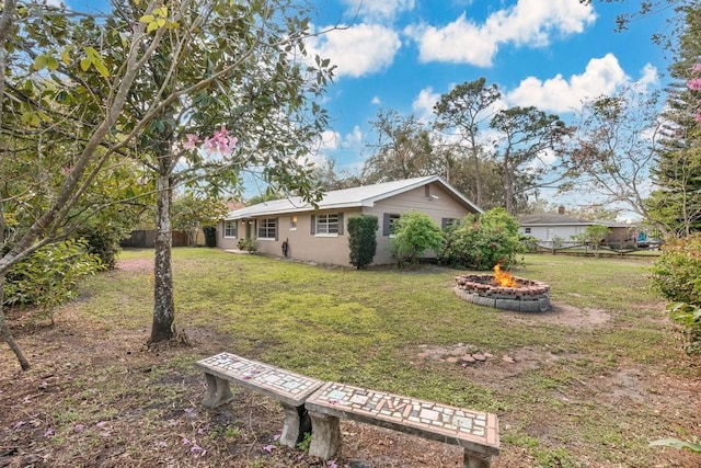 view of yard featuring a fire pit and fence