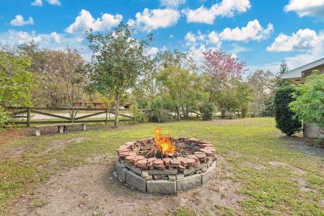 view of yard featuring an outdoor fire pit and fence