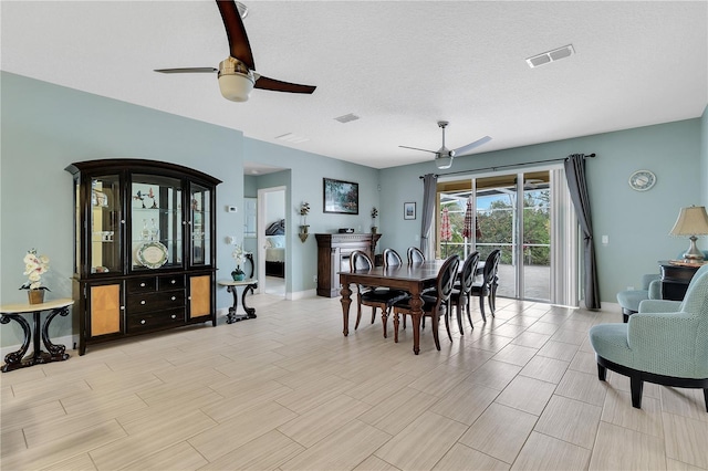 dining space featuring a textured ceiling and ceiling fan