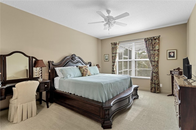 bedroom featuring ceiling fan, light colored carpet, and a textured ceiling