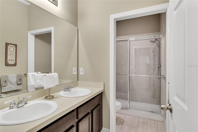 bathroom with vanity, a shower with shower door, and toilet