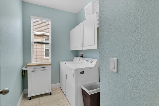 washroom with cabinets and washer and dryer