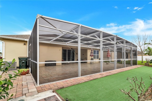 back of property featuring a lanai and a patio area