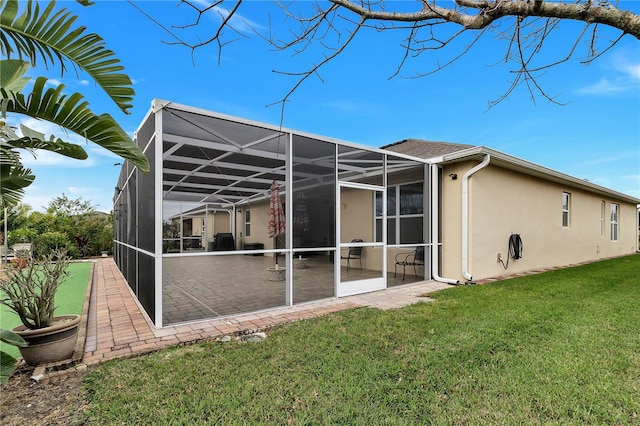 view of side of property featuring a patio, a lanai, and a yard