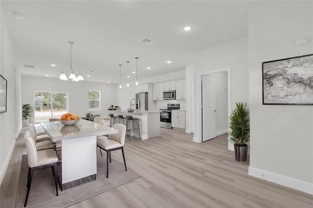 dining area featuring a chandelier and light hardwood / wood-style floors