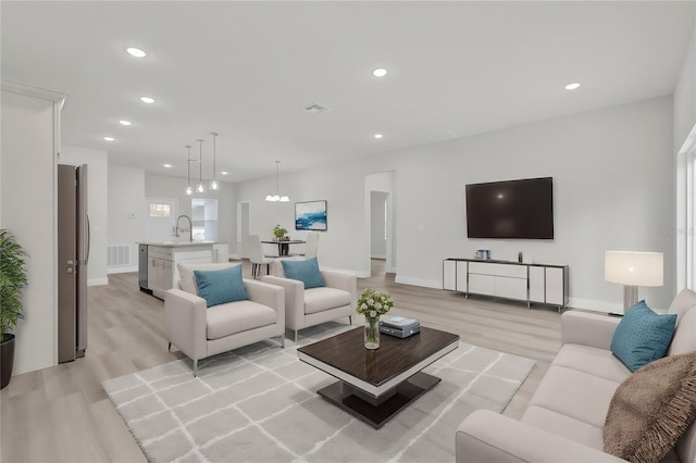 living room with sink and light hardwood / wood-style flooring