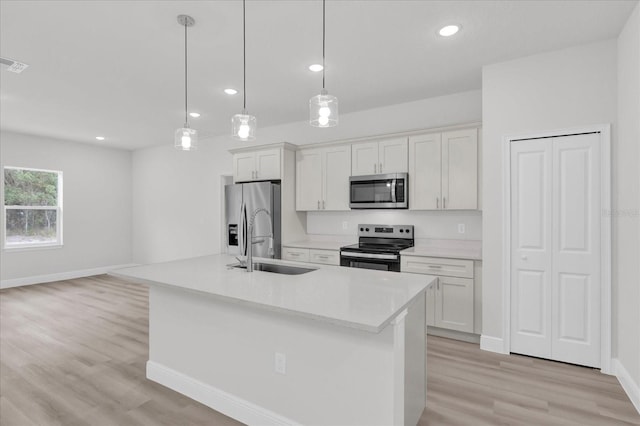 kitchen featuring stainless steel appliances, hanging light fixtures, and white cabinets