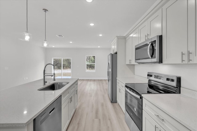 kitchen with sink, decorative light fixtures, light wood-type flooring, stainless steel appliances, and white cabinets