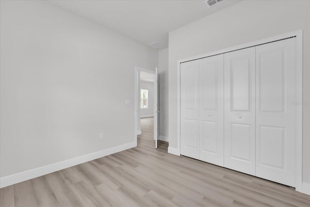 unfurnished bedroom with light hardwood / wood-style floors and a closet