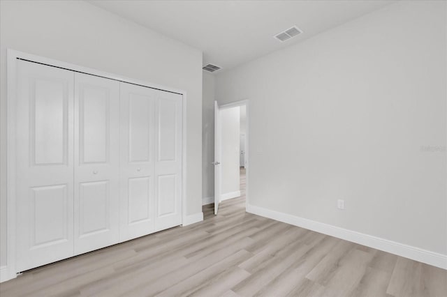 unfurnished bedroom featuring a closet and light wood-type flooring