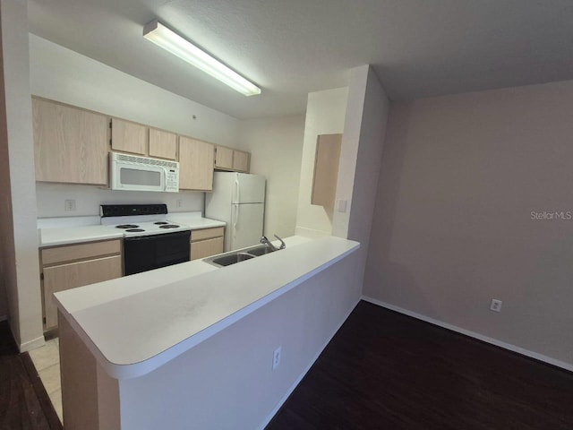 kitchen with sink, hardwood / wood-style flooring, kitchen peninsula, light brown cabinets, and white appliances