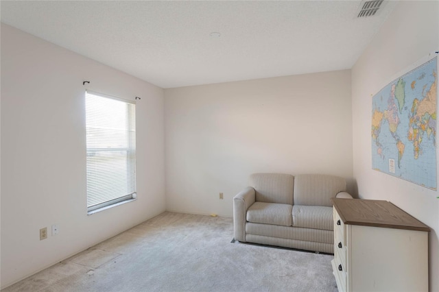 living area featuring light carpet