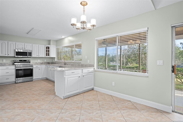 kitchen with appliances with stainless steel finishes, decorative light fixtures, white cabinets, light tile patterned floors, and light stone counters