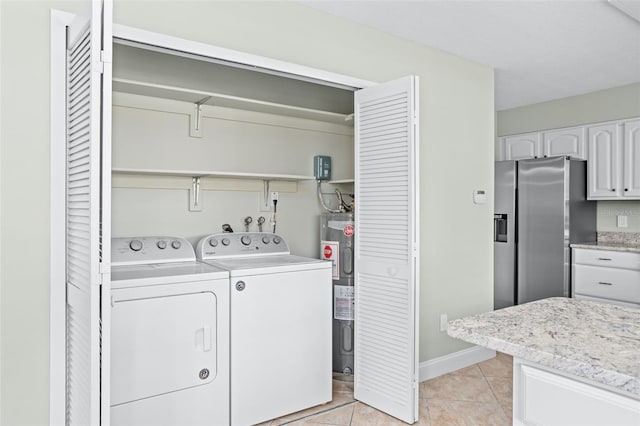 laundry area with independent washer and dryer, electric water heater, and light tile patterned floors