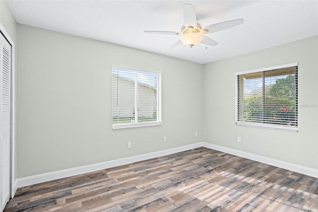 unfurnished bedroom with wood-type flooring, a closet, and ceiling fan