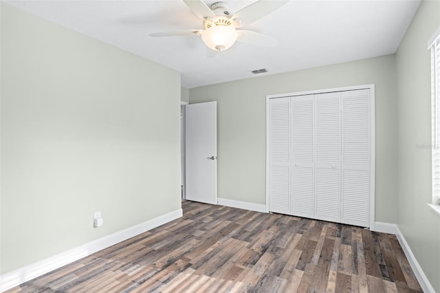 unfurnished bedroom with ceiling fan, dark hardwood / wood-style floors, and a closet