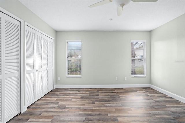 unfurnished bedroom featuring ceiling fan and dark hardwood / wood-style floors