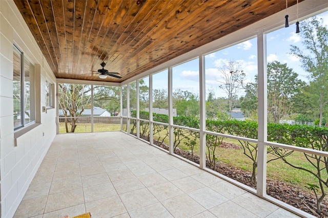 unfurnished sunroom featuring wood ceiling and ceiling fan