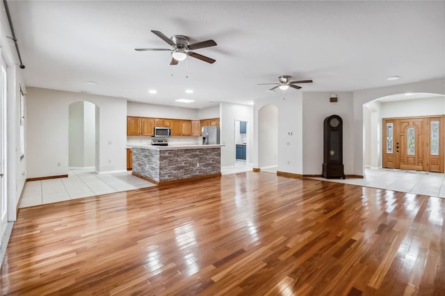 unfurnished living room with ceiling fan and light hardwood / wood-style floors