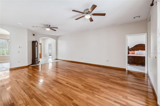 unfurnished living room featuring ceiling fan and light wood-type flooring