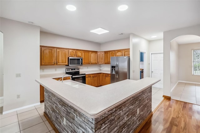 kitchen featuring stainless steel appliances, sink, and light tile patterned floors