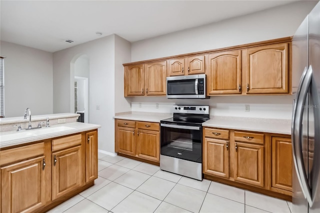 kitchen featuring light tile patterned flooring, appliances with stainless steel finishes, and sink