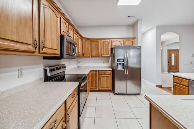 kitchen with light tile patterned floors and stainless steel appliances