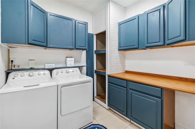 clothes washing area featuring independent washer and dryer, cabinets, and light tile patterned flooring