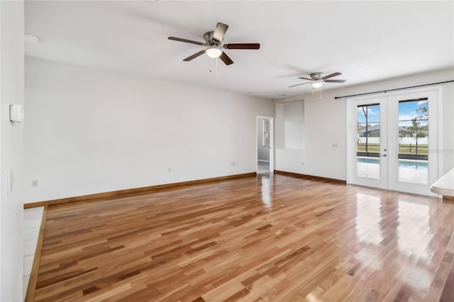 unfurnished living room with wood-type flooring, ceiling fan, and french doors