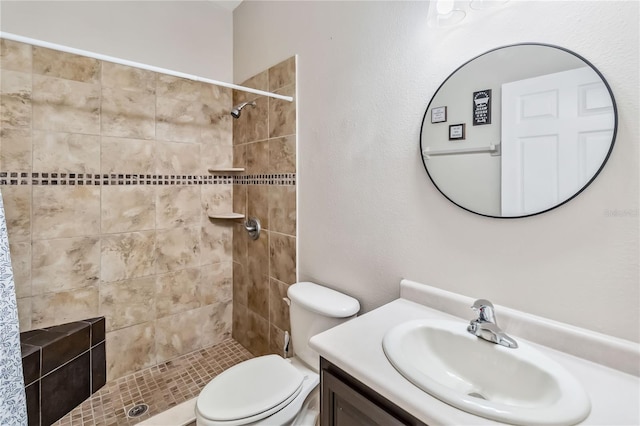 bathroom with vanity, toilet, and a tile shower