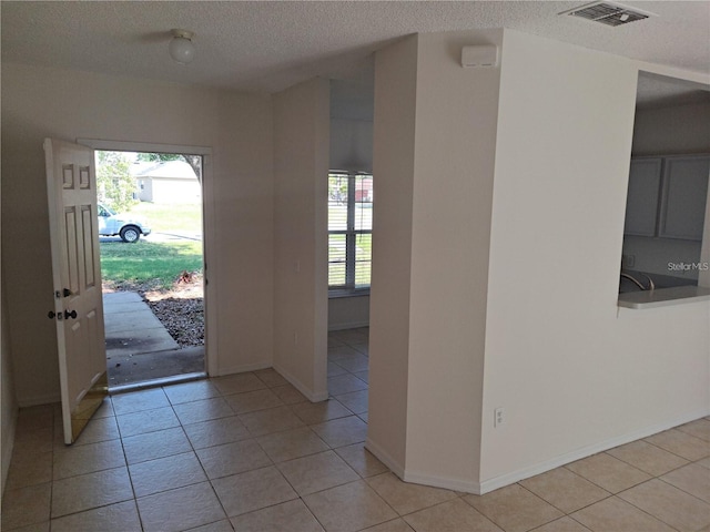 entrance foyer with light tile patterned floors and a textured ceiling